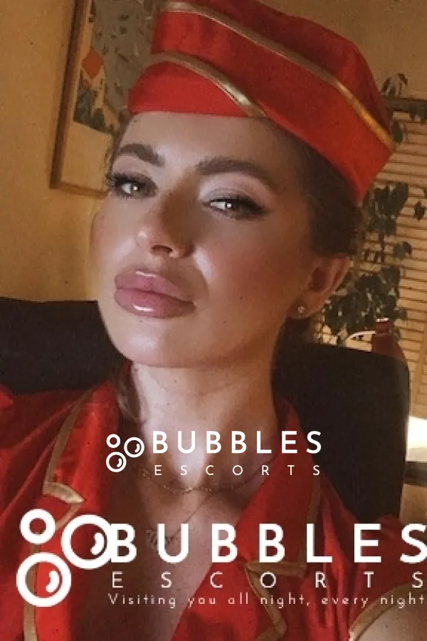 Tasha taking a selfie wearing a red flight attendance uniform 