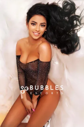 Karina lay on a bed wearing a see through outfit