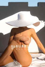Jessica sitting in a large white hat while naked 
